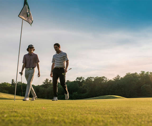 Two gentlemen walking through Trappers Turn Golf Course.